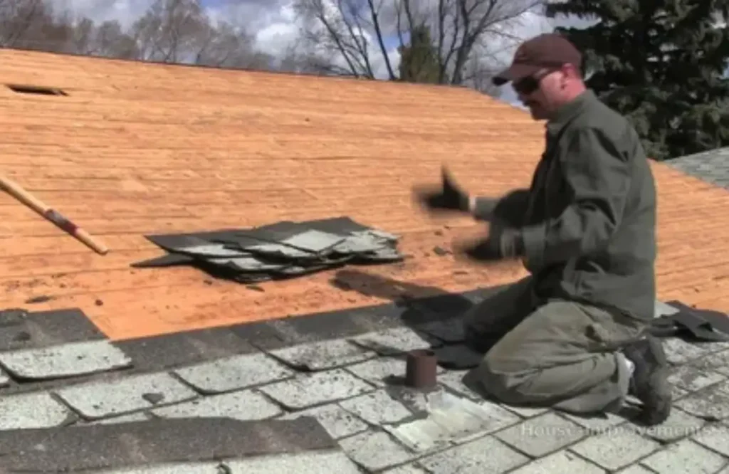 Person repairing asphalt shingles on roof.